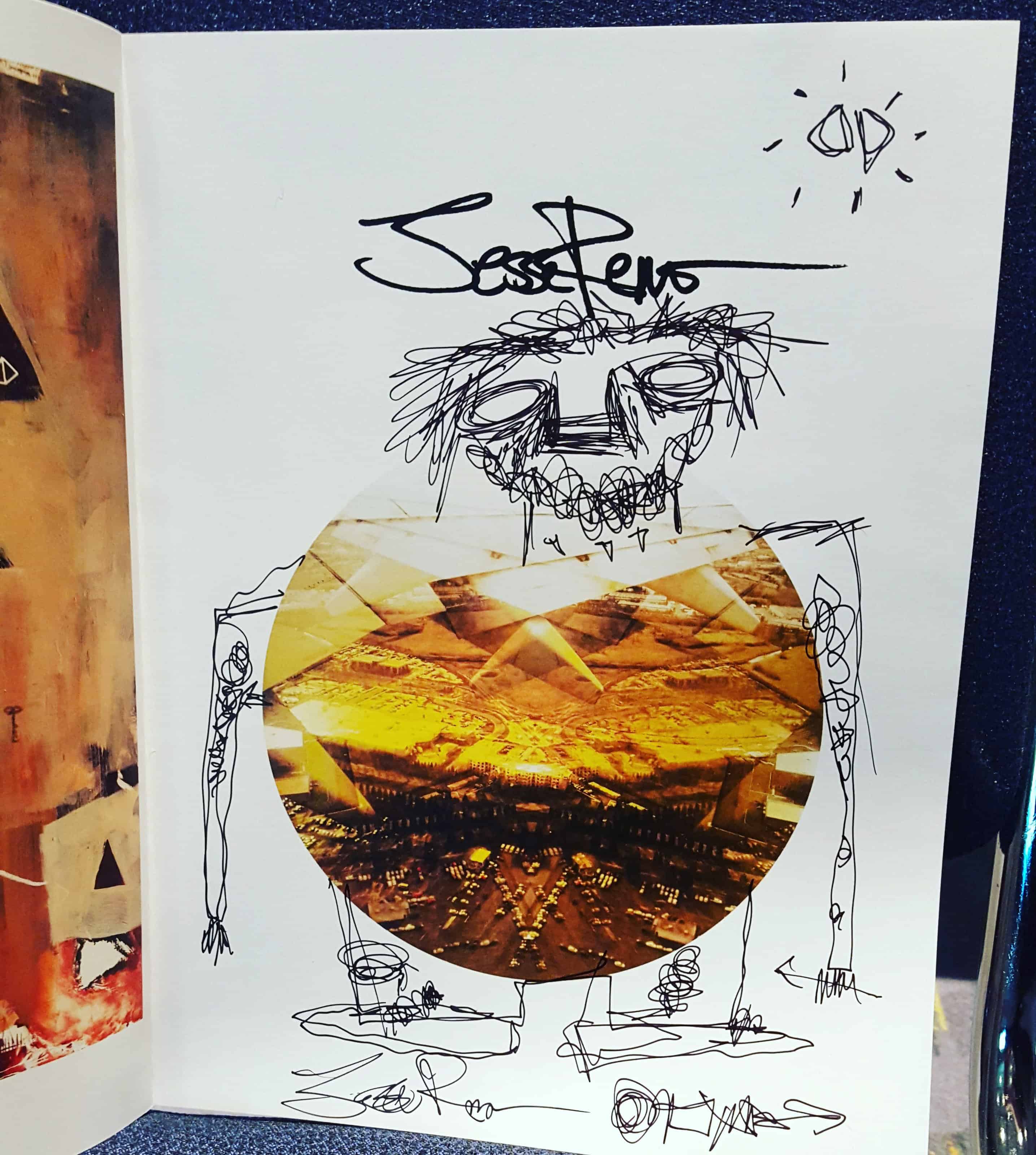 Abstract sketch with scribbled figure holding a circular photo of a desert landscape. Text above reads "Jesse Reno."