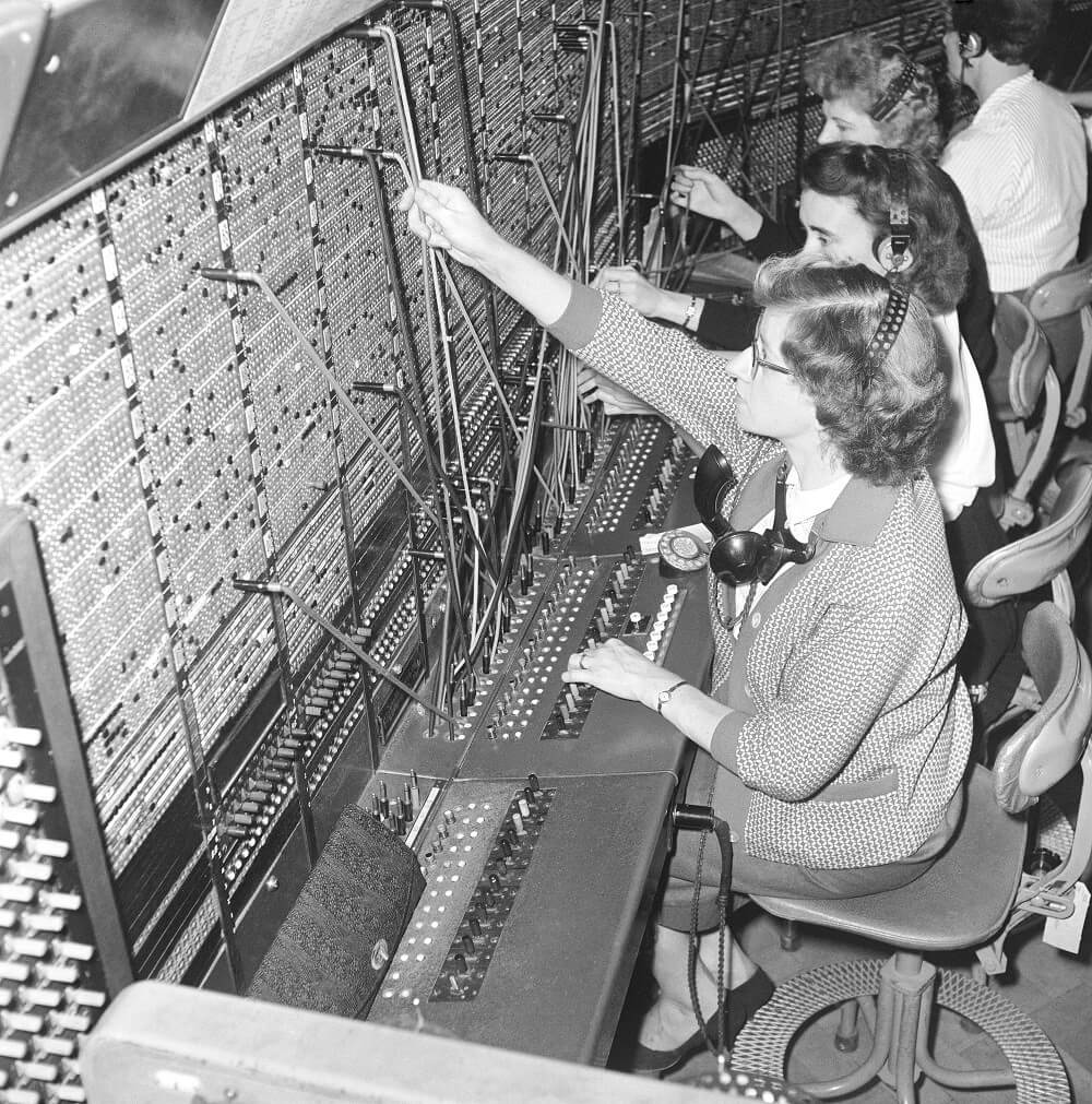 Three female workers operating a switchboard