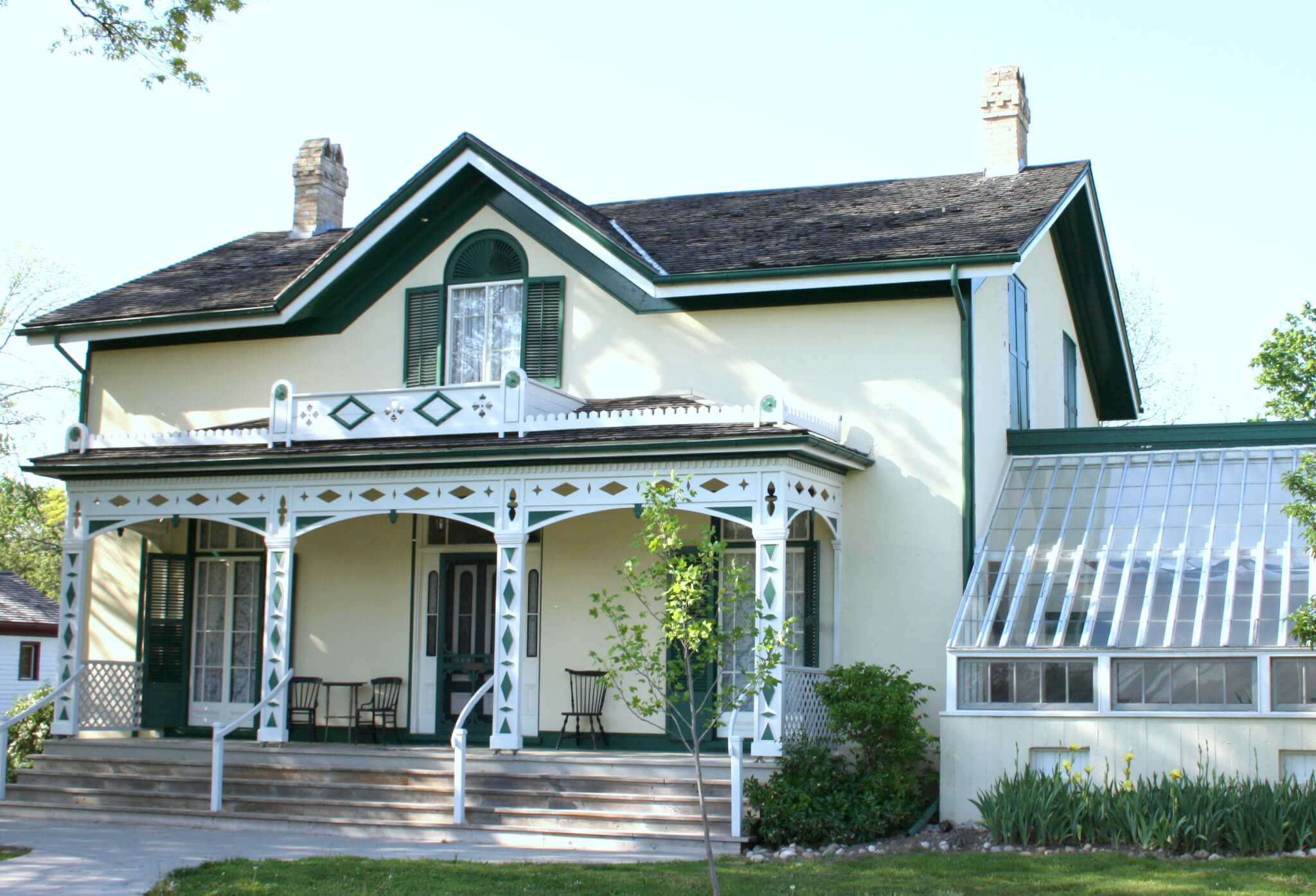 A yellow house with a white porch.