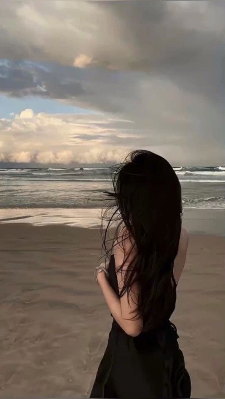 Ảnh chụp sau lưng nữ tóc ngắn bay trong gió biển lãng mạn