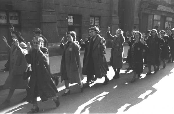 Jewish Hungarian women with their arms raised and wearing star of davids.