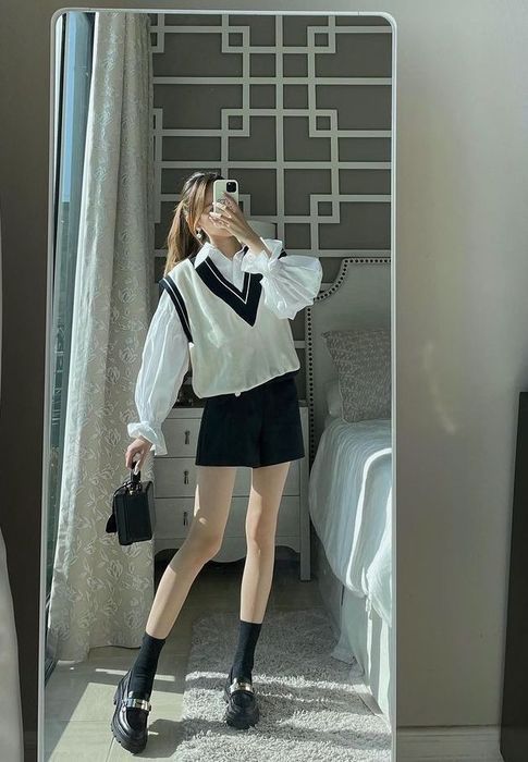 Ảnh một cô gái xinh đẹp mặc váy ngắn che mặt bằng điện thoại. Gái xinh váy ngắn đang làm gì thế nhỉ?