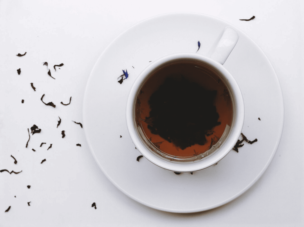 Earl Grey tea in a white cup on a white saucer .
