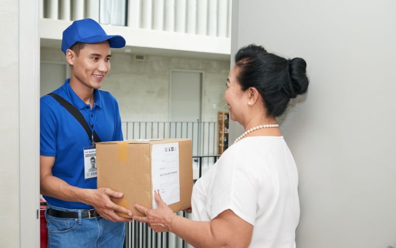 Bưu tá vận chuyển và giao hàng đến tận tay người nhận