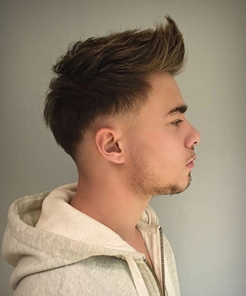 Long quiff hairstyle with bold height on top and tapered low sides.