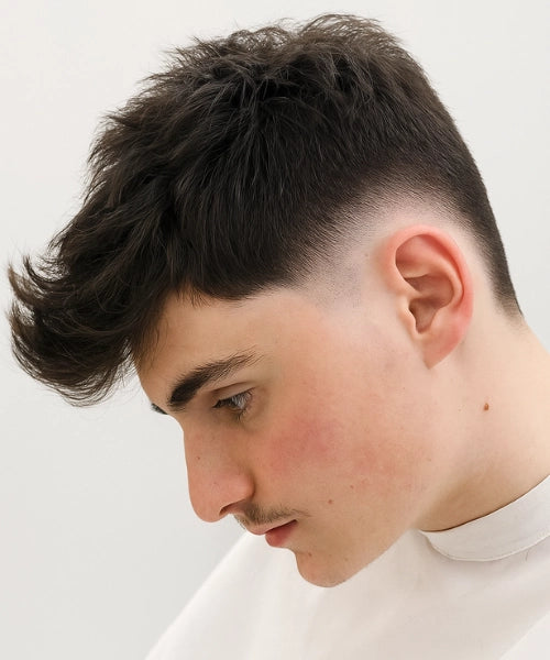 Burst fade quiff haircut with lifted textured top and bold faded side shape.
