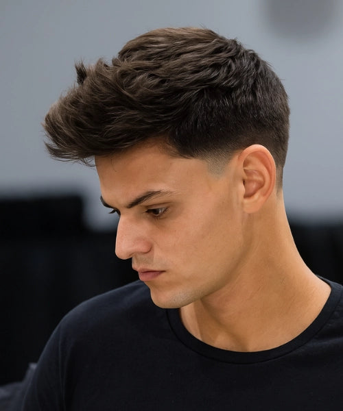 Low taper quiff haircut with voluminous textured top and subtle tapered sides.