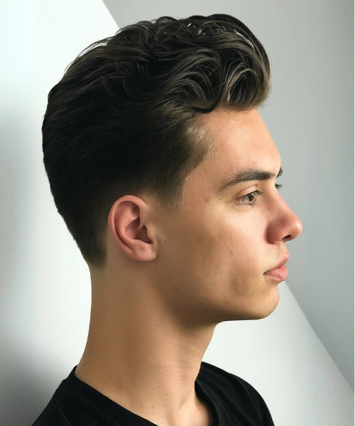 Slick back quiff haircut with voluminous swept-back top and faded sides.