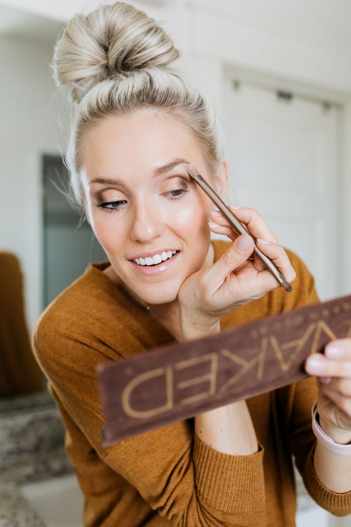 NAKED Palette Tutorial featured by top US beauty blog A Slice of Style; Image of woman in mustard sweater, applying eye shadow.