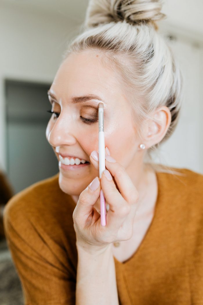 NAKED Palette Tutorial featured by top US beauty blog A Slice of Style; Image of woman in mustard sweater, applying eye shadow.