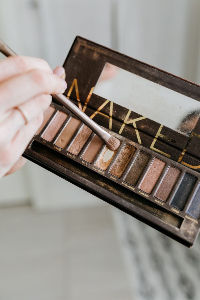 NAKED Palette Tutorial featured by top US beauty blog A Slice of Style; Image of woman in mustard sweater, applying eye shadow.