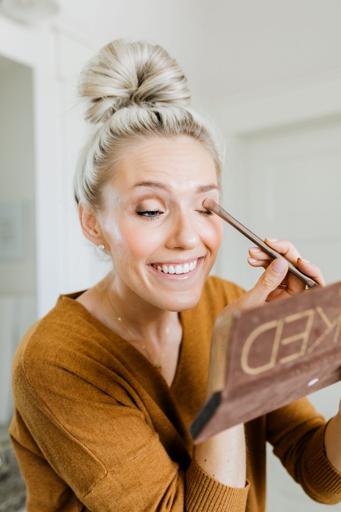 NAKED Palette Tutorial featured by top US beauty blog A Slice of Style; Image of woman in mustard sweater, applying eye shadow.