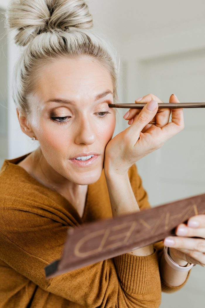 NAKED Palette Tutorial featured by top US beauty blog A Slice of Style; Image of woman in mustard sweater, applying eye shadow.