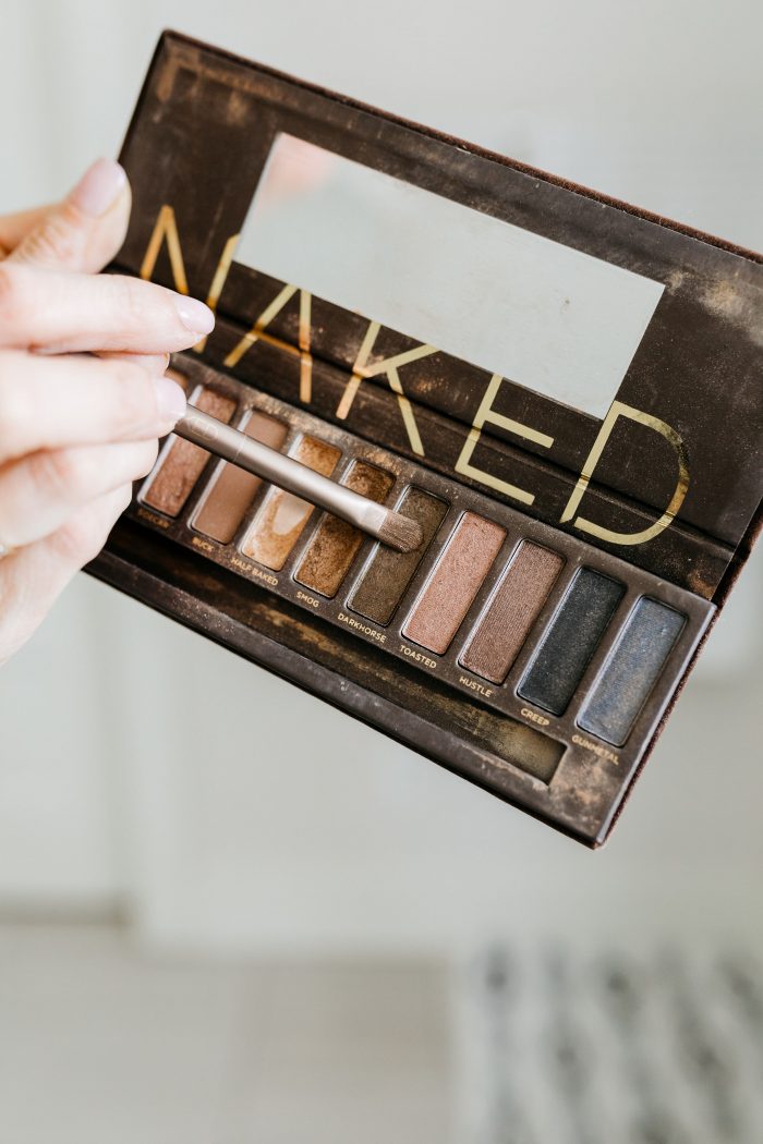 NAKED Palette Tutorial featured by top US beauty blog A Slice of Style; Image of woman in mustard sweater, applying eye shadow.
