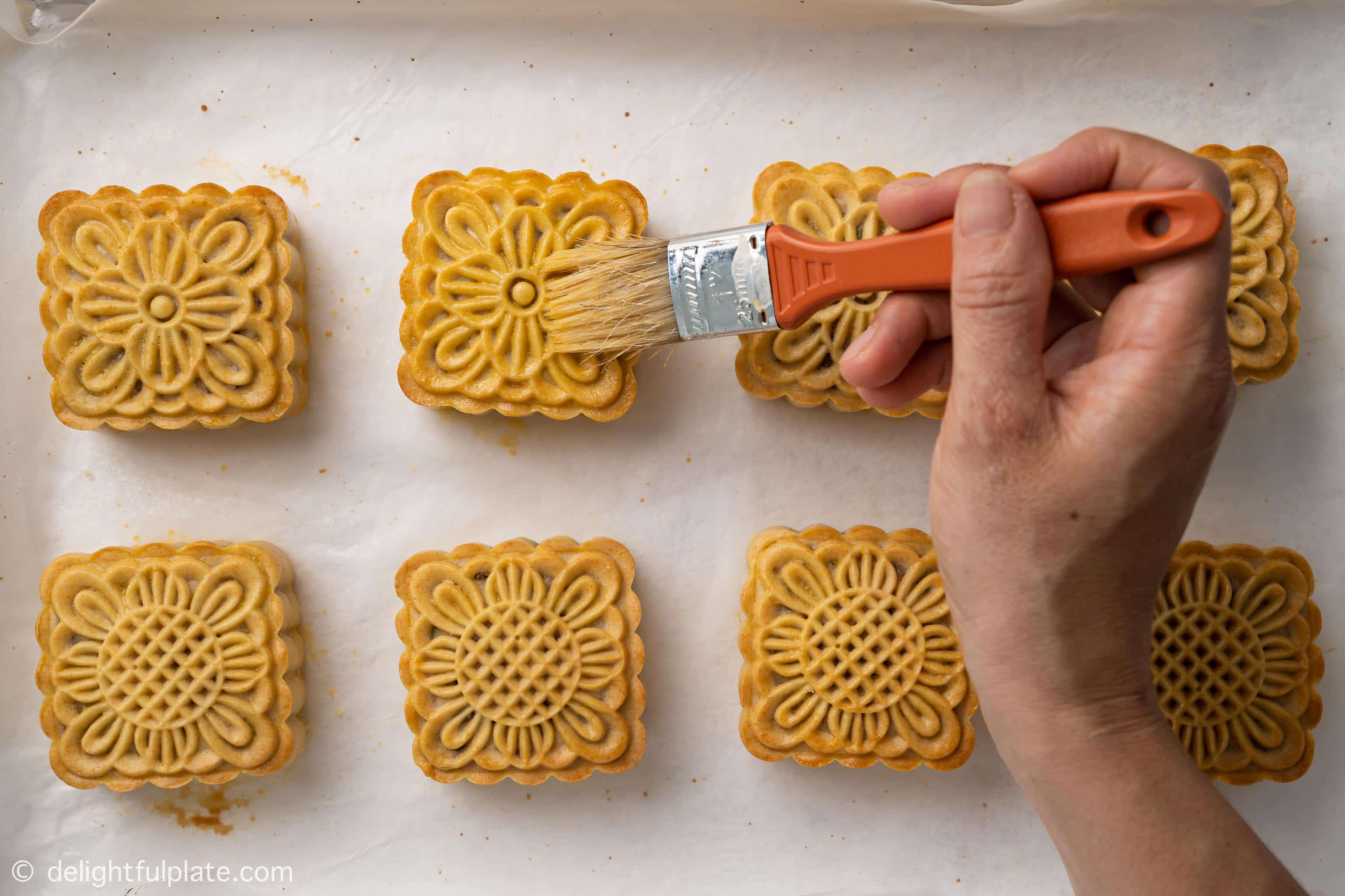 brushing mooncakes with egg wash