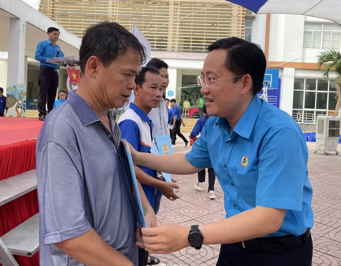 Phó Chủ tịch LĐLĐ TPHCM Phùng Thái Quang trao quà đến công nhân bị tai nạn lao động. Ảnh: SGGP